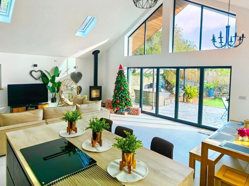 A living room with a Christmas tree and large windows at 4 Bed Villa Sleeps 8 Private Terrace Free parking near St Austell