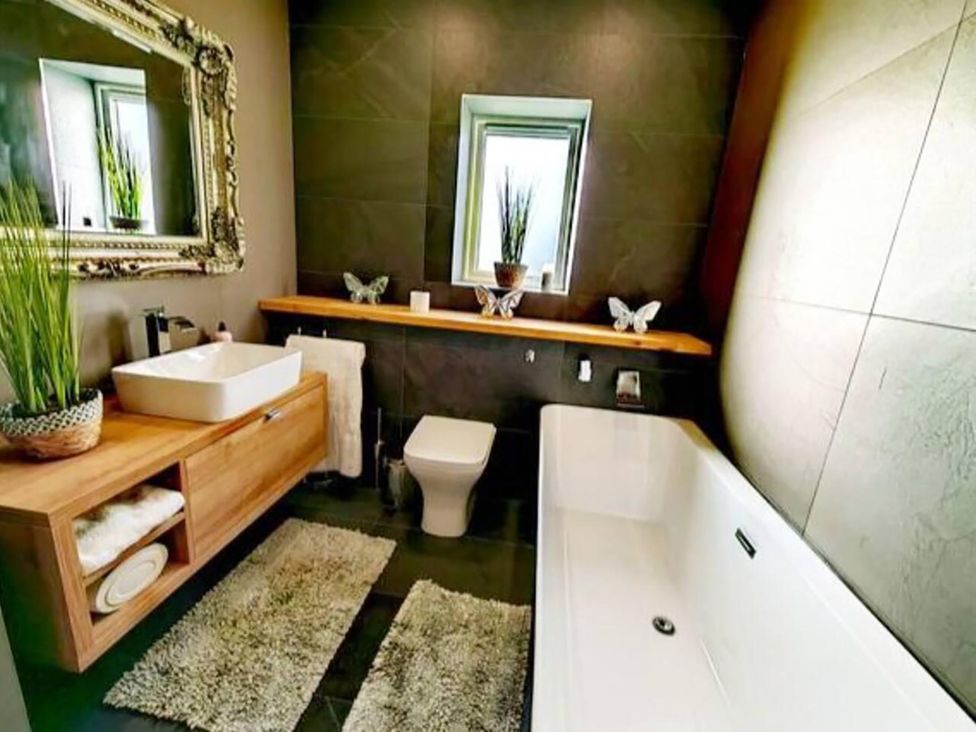 A bathroom with a bathtub, sink, and toilet at 4 Bed Villa Sleeps 8 Private Terrace Free parking near St Austell