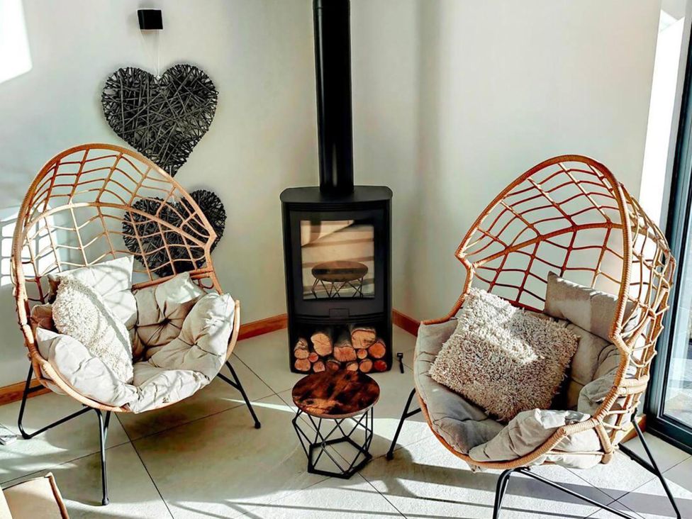 A living room with chairs and a fireplace at 4 Bed Villa Sleeps 8 Private Terrace Free parking near St Austell