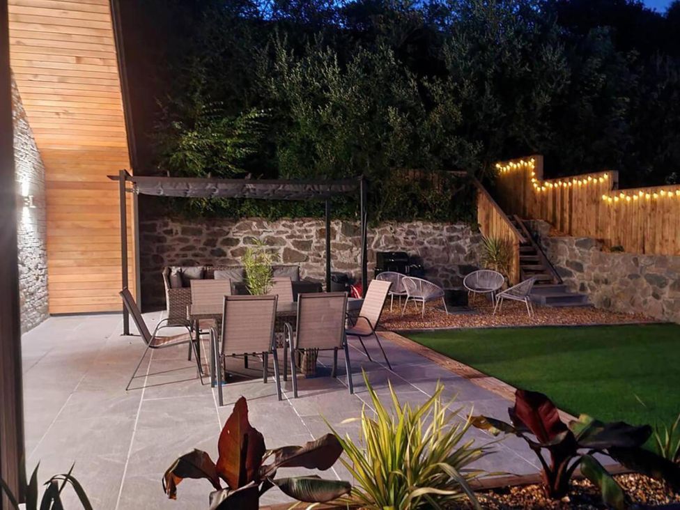 A sitting area with chairs and tables in a garden at 4 Bed Villa Sleeps 8 Private Terrace Free parking Near St Austell