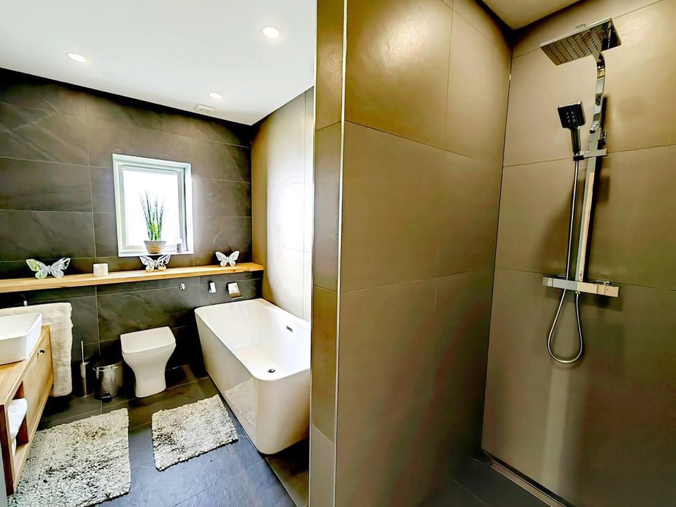 A bathroom with a bathtub and shower at 4 Bed Villa Sleeps 8 Private Terrace Free parking near St Austell