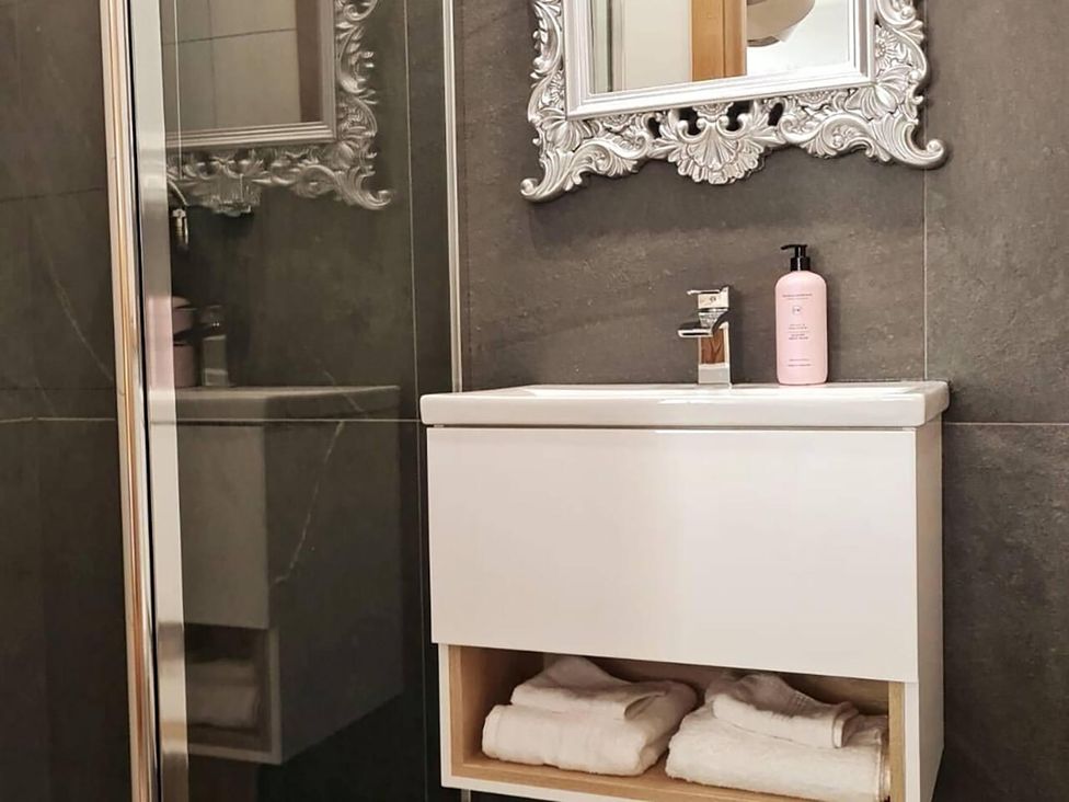 A bathroom with a sink and mirror in 4 Bed Villa Sleeps 8 Private Terrace Free parking Near St Austell