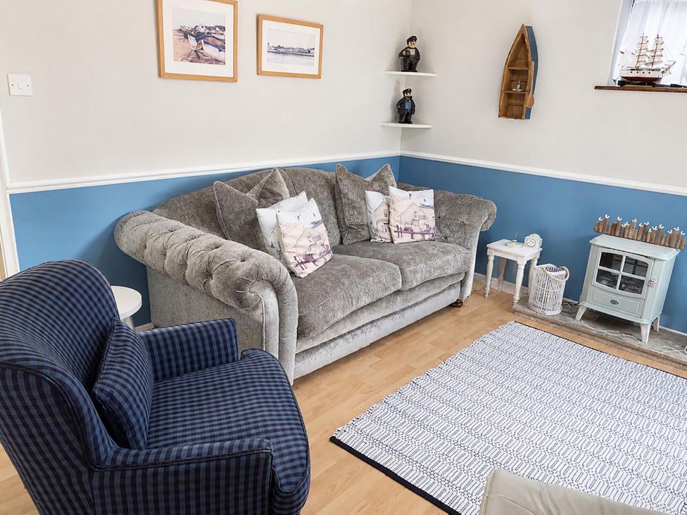 A living room with a sofa and decorative items at Coastal Chalet Retreat in St Margaret's Bay