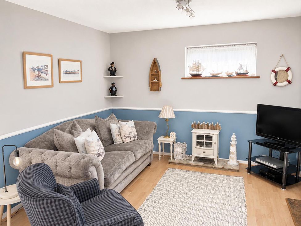 A living room with a sofa and a television at Coastal Chalet Retreat in St Margaret's Bay
