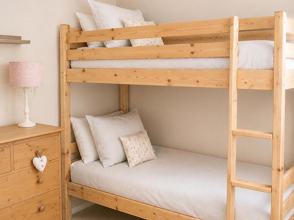 A bedroom with a bunk bed and dresser at Coastal Chalet Retreat in St Margaret's Bay