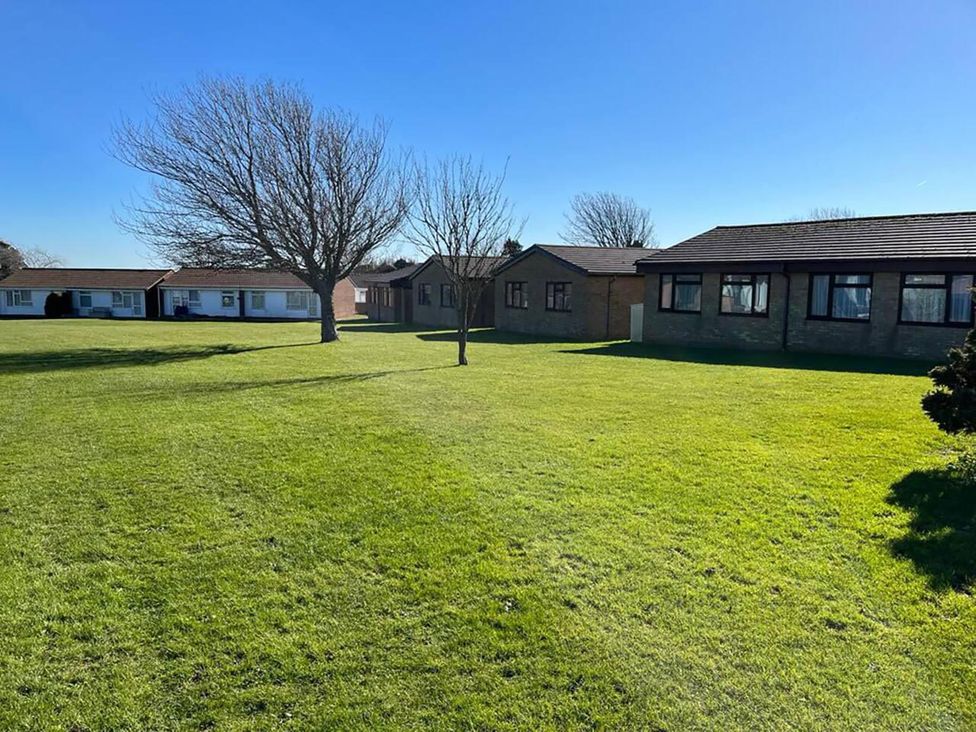 An outdoor area with buildings and a tree at Coastal Chalet Retreat in St Margaret's Bay