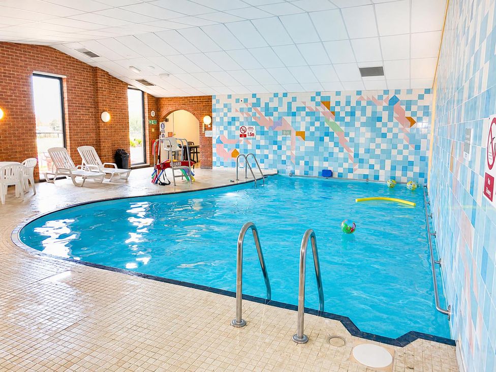 An indoor pool with lounge chairs and pool toys at Coastal Chalet Retreat in St Margaret's Bay