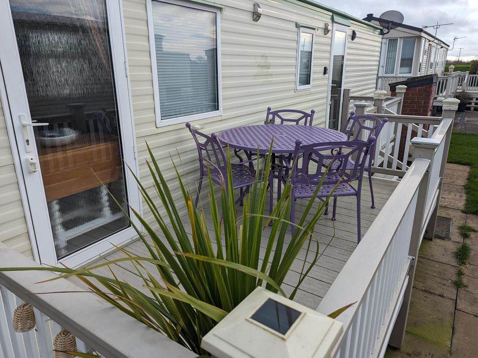 An outdoor seating area with purple furniture at Sandy Paws Dog Friendly Anderby Creek