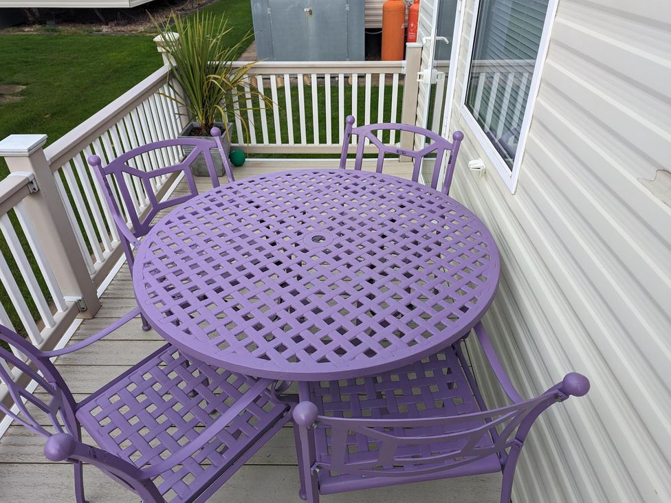 A table and chairs on an outdoor deck at Sandy Paws Dog Friendly Anderby Creek