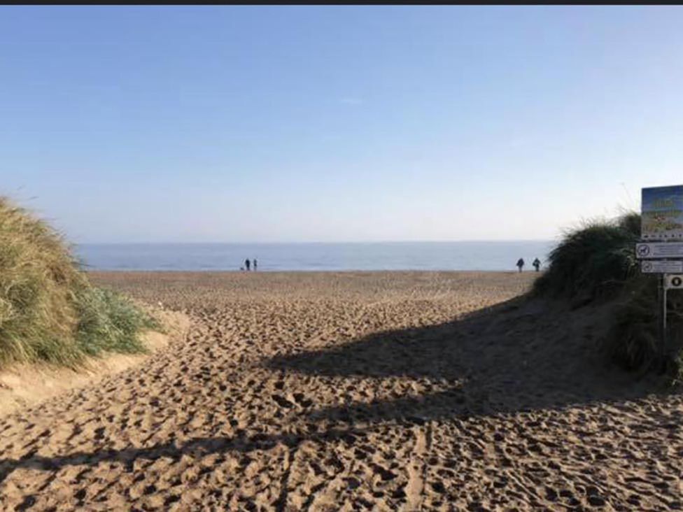 A beach scene with sand and sea at Sandy Paws Dog Friendly Anderby Creek
