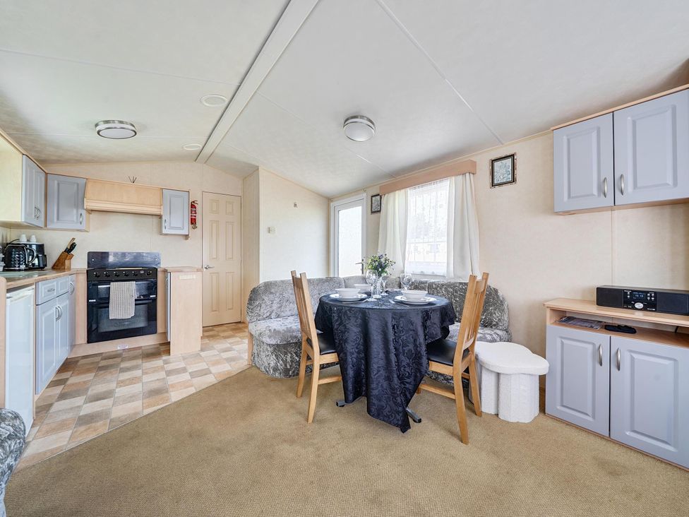 A living room with a table and chairs at 3 Bed Caravan Sleeps 8 Pets Garden Parking in Hull
