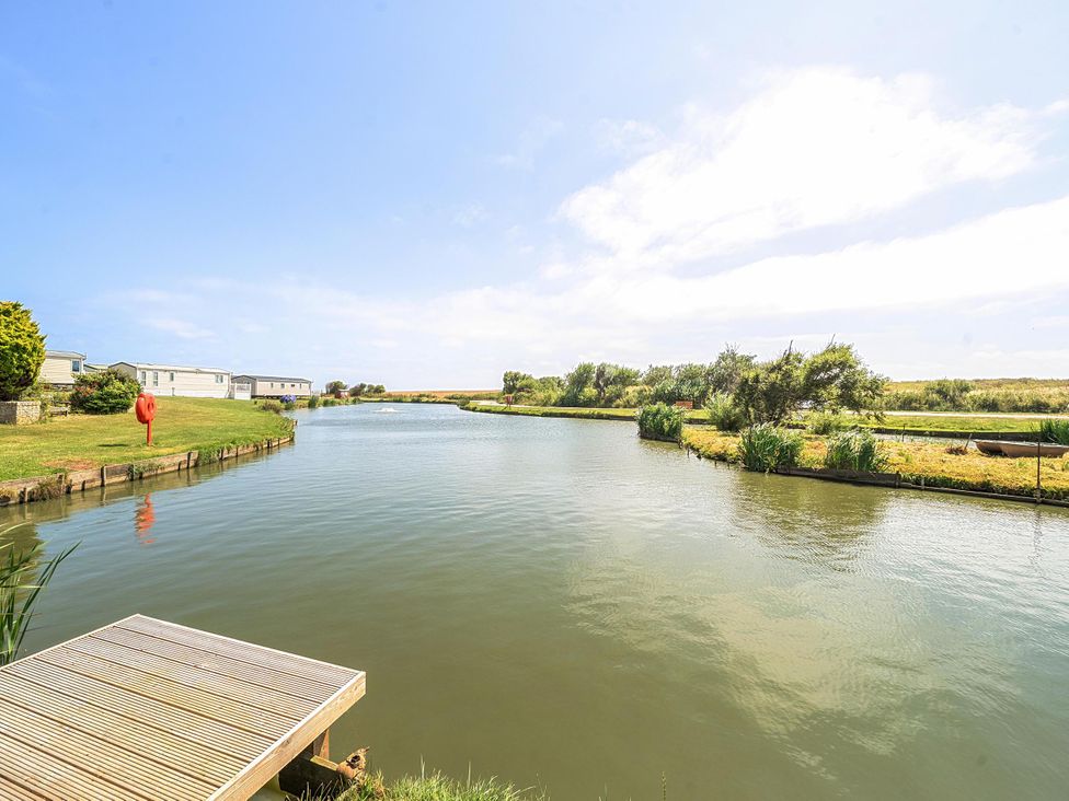 A view of a pond with caravans and greenery at 3 Bed Caravan Sleeps 8 Pets Garden Parking Hull