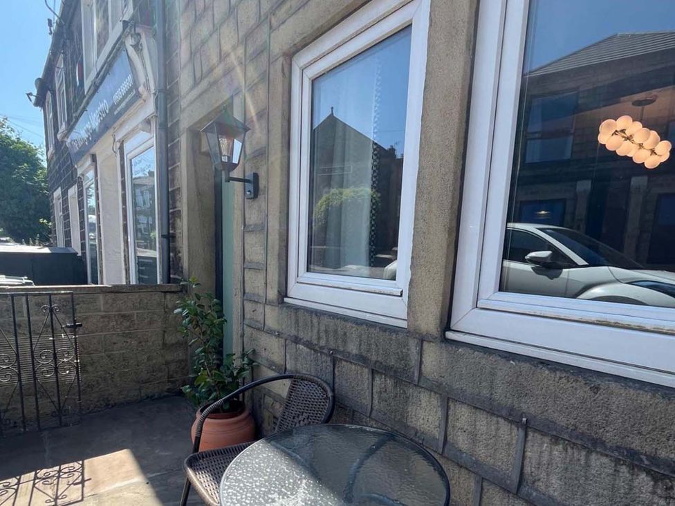 An outdoor seating area with a table and chairs at Cozy Cottage Retreat near Haworth log burner Keighley