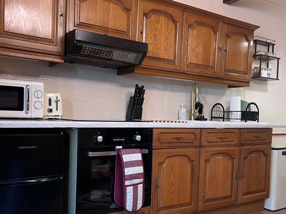 A kitchen with cabinets and appliances at Cozy Cottage Retreat near Haworth log burner Keighley