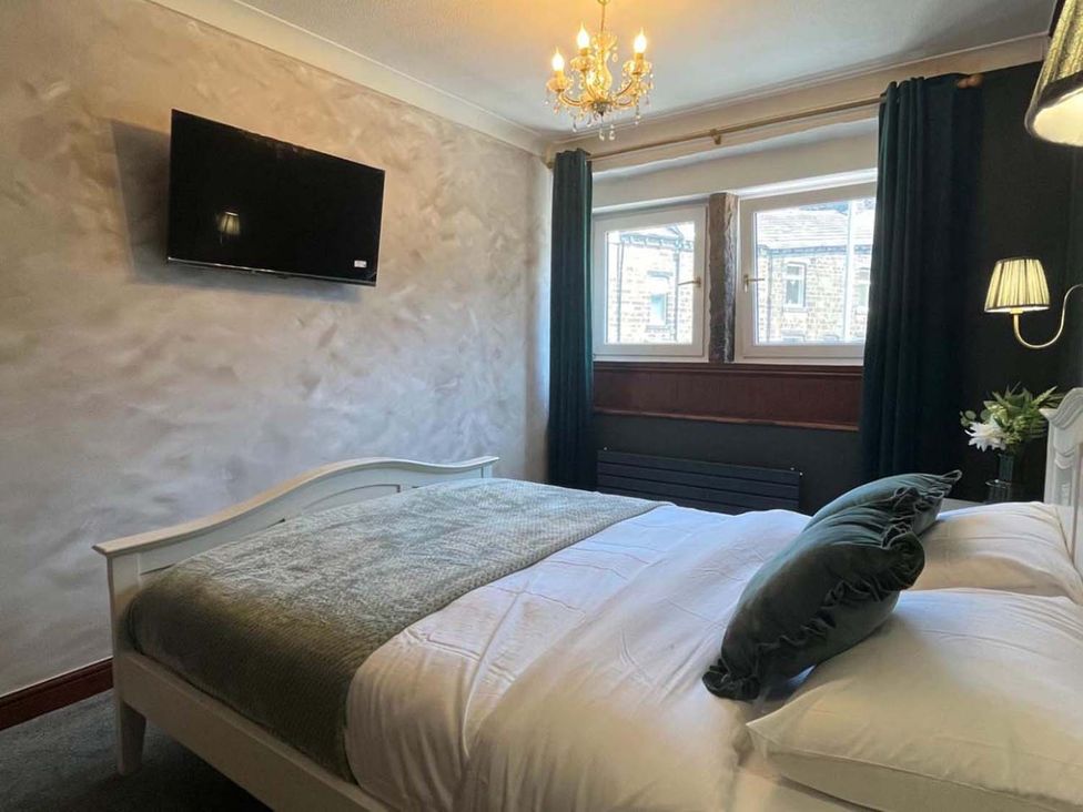 A bedroom with a bed and television at Cozy Cottage Retreat near Haworth log burner, Keighley