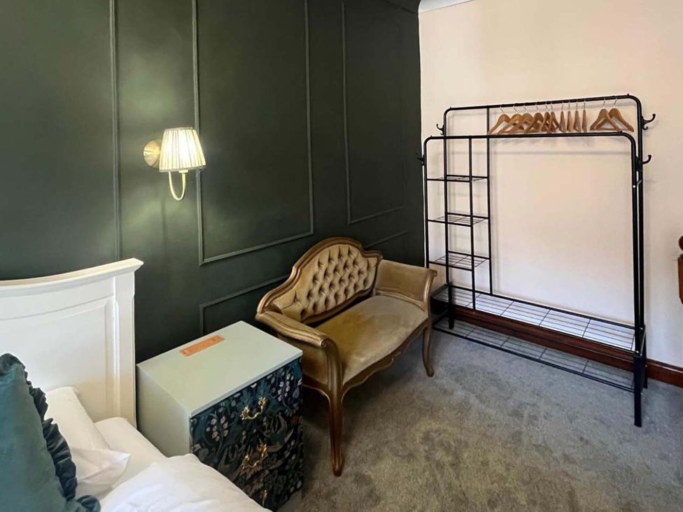 A bedroom with a bed and seating area at Cozy Cottage Retreat near Haworth log burner Keighley
