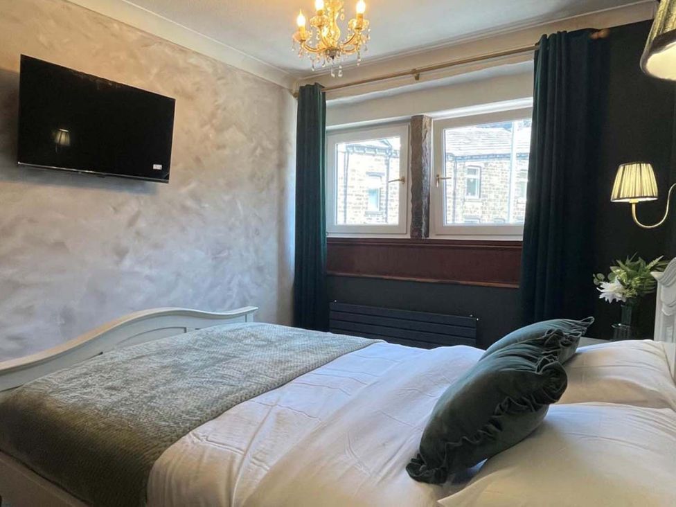 A bedroom with a bed and television at Cozy Cottage Retreat near Haworth log burner in Keighley