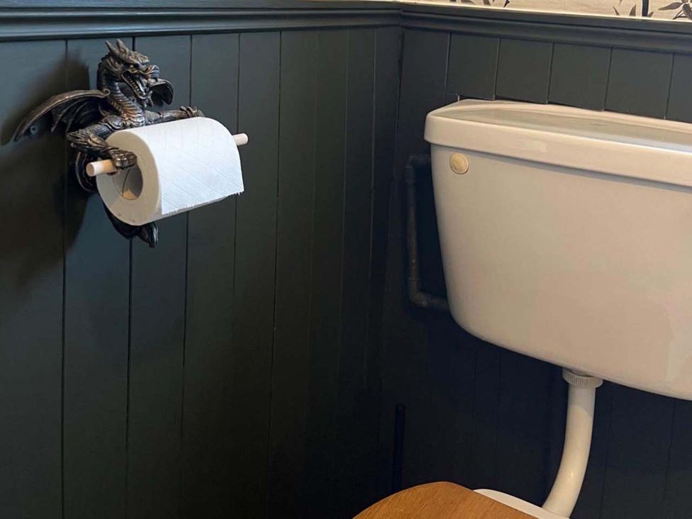 A bathroom with a toilet and toilet roll holder at Cozy Cottage Retreat near Haworth log burner in Keighley