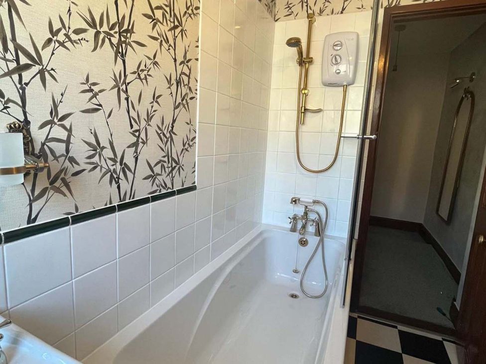 A bathroom with bathtub and shower unit at Cozy Cottage Retreat near Haworth log burner Keighley