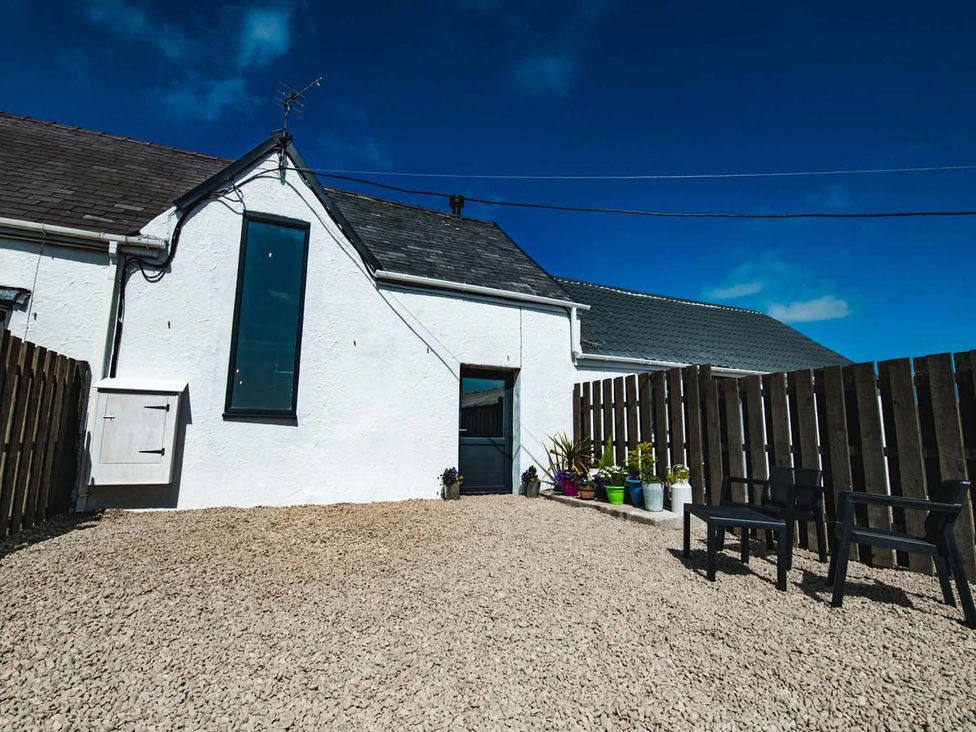 An outdoor area with gravel and chairs at The Milking Shed at Pencraig Pet Friendly near Holyhead