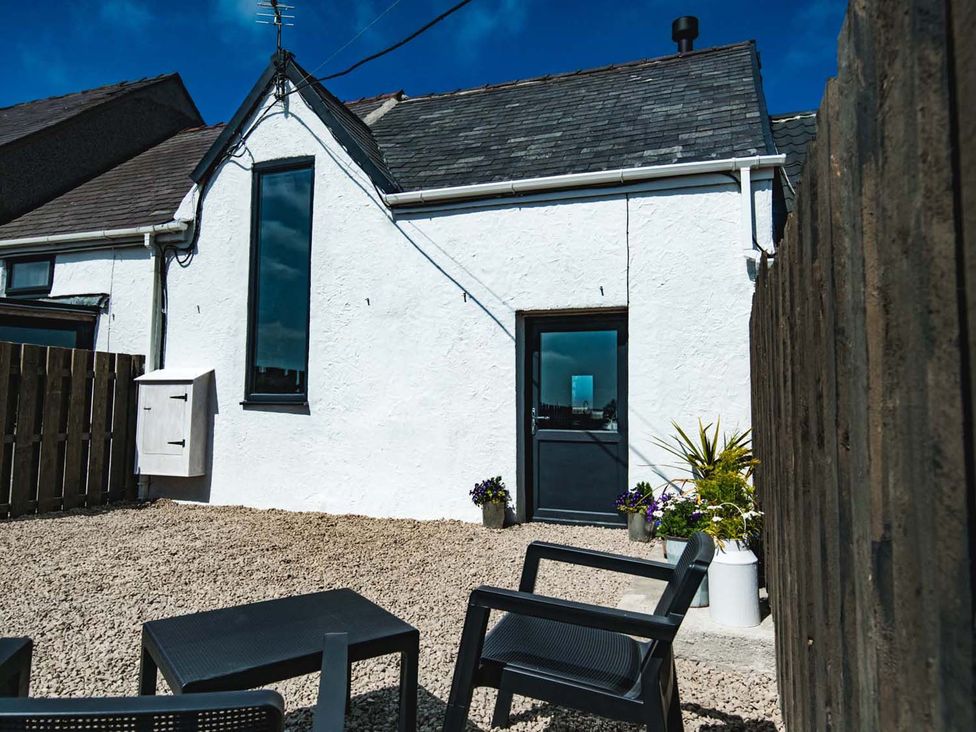 An outdoor area with gravel and chairs at The Milking Shed at Pencraig Pet Friendly, Llanynghenedl near Holyhead
