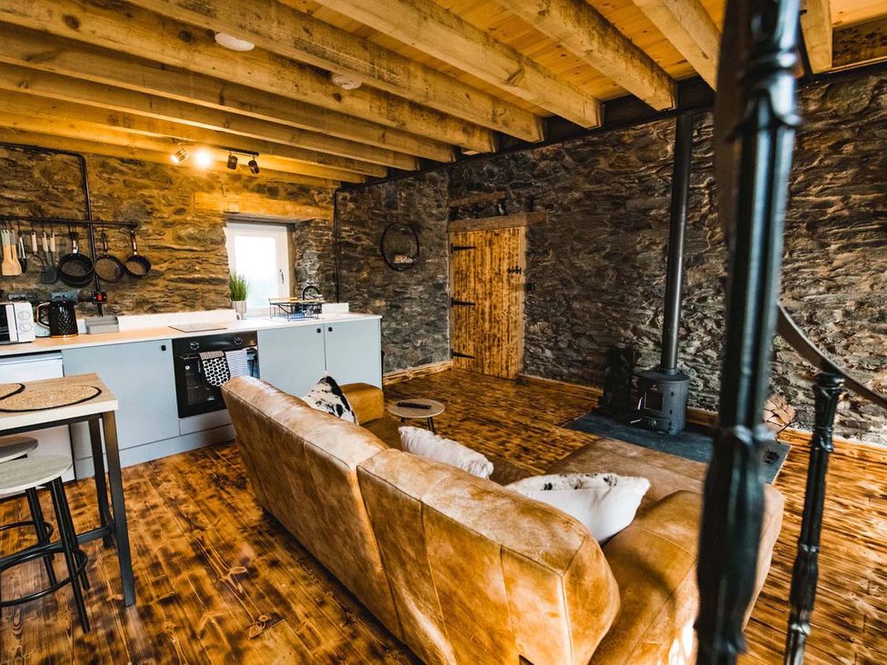 A living room with a kitchen area at The Milking Shed at Pencraig Pet Friendly, Llanynghenedl near Holyhead