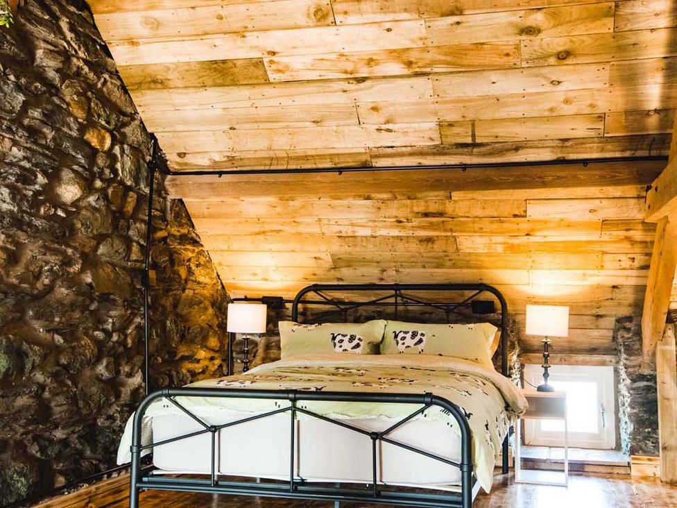 A bedroom with a bed and lamps at The Milking Shed at Pencraig Pet Friendly, Llanynghenedl near Holyhead