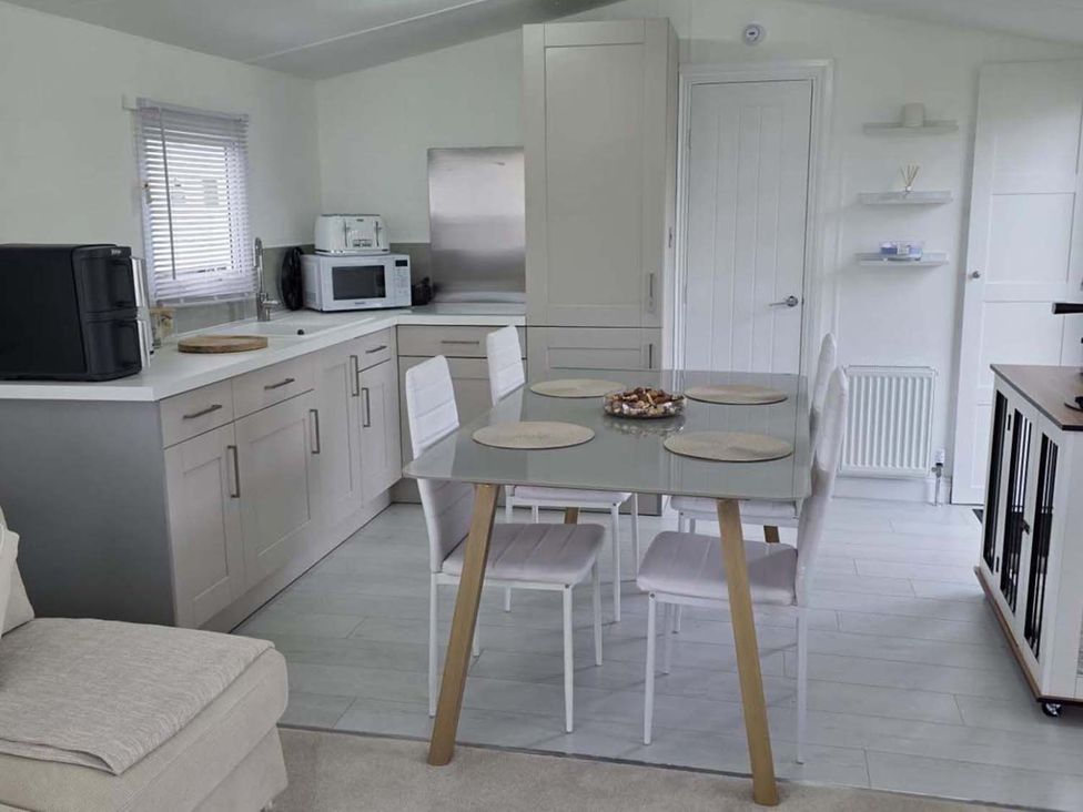 A kitchen with a table and chairs at Luxury Cosy Caravan in Cresswell Northumberland