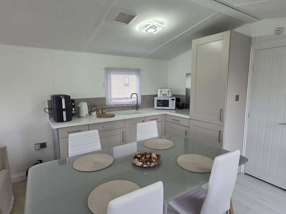 A kitchen with a table and chairs at Luxury Cosy Caravan in Cresswell Northumberland