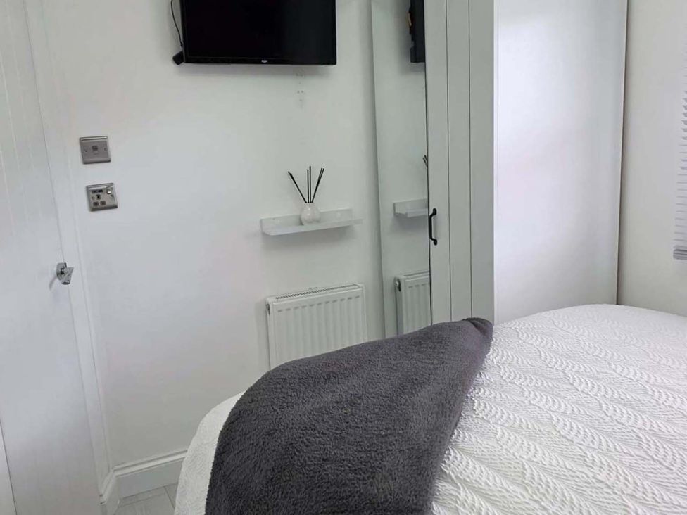 A bedroom with a television and a wardrobe at Luxury Cosy Caravan in Cresswell Northumberland