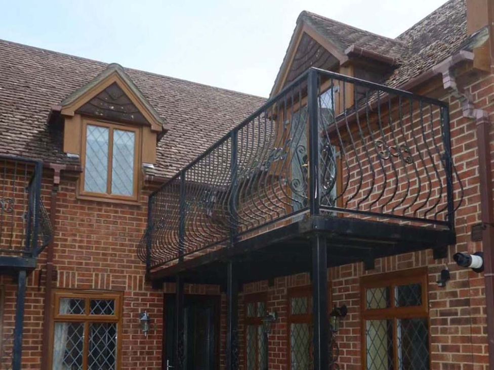 A balcony with railings and windows at an outdoor setting
