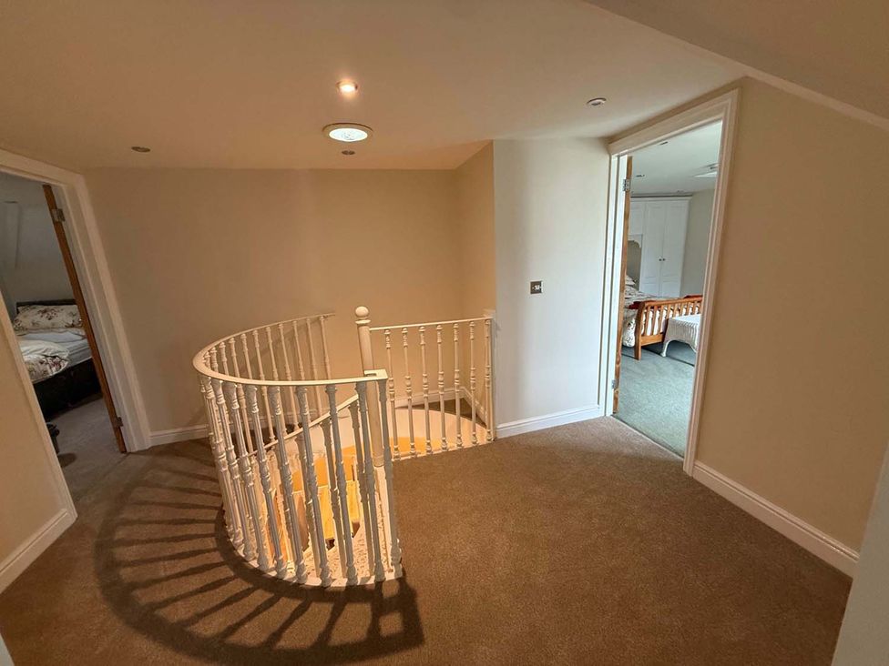 A hallway with a staircase leading down at The Old Barn in Manchester