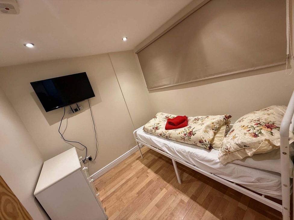 A bedroom with a bed and television at The Old Barn in Manchester