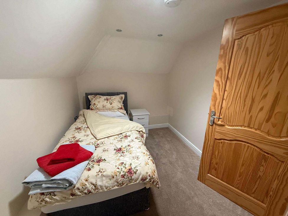 A bedroom with a bed and side table at The Old Barn in Manchester