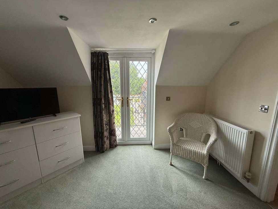 A bedroom with a television and patio doors at the property