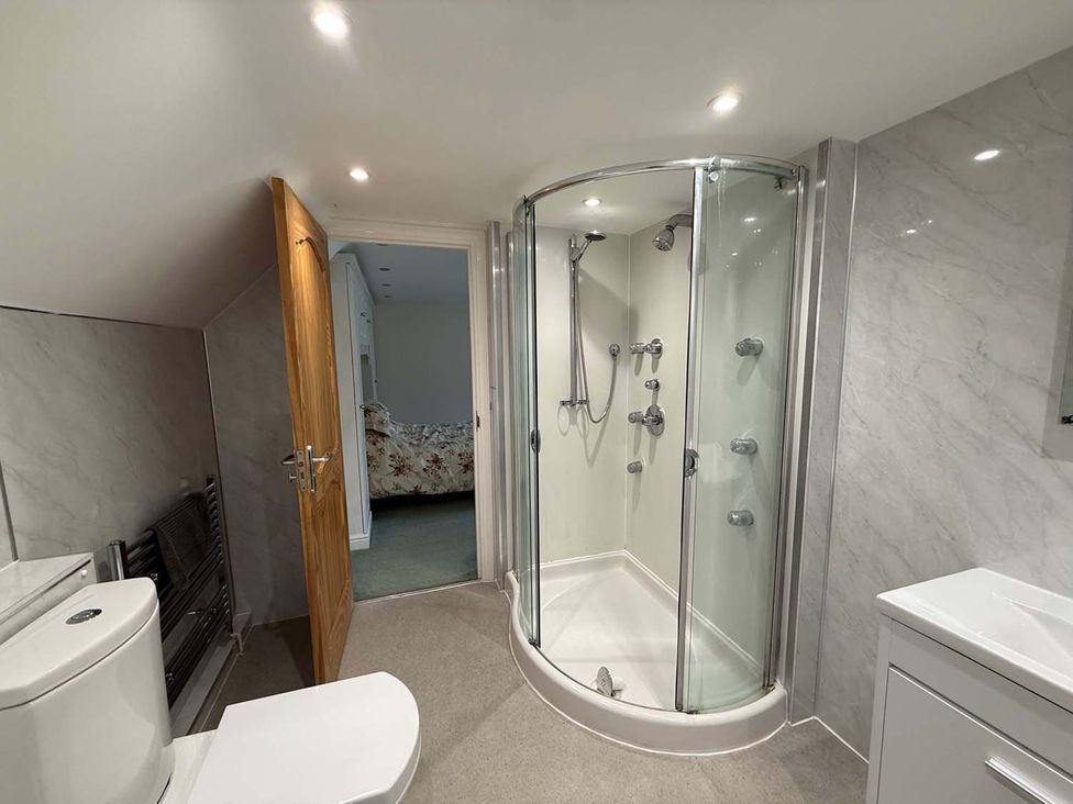 A bathroom with a shower, toilet and sink in a home