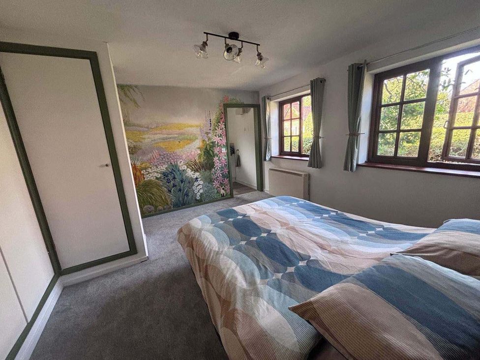 A bedroom with a bed and mural at the property in 