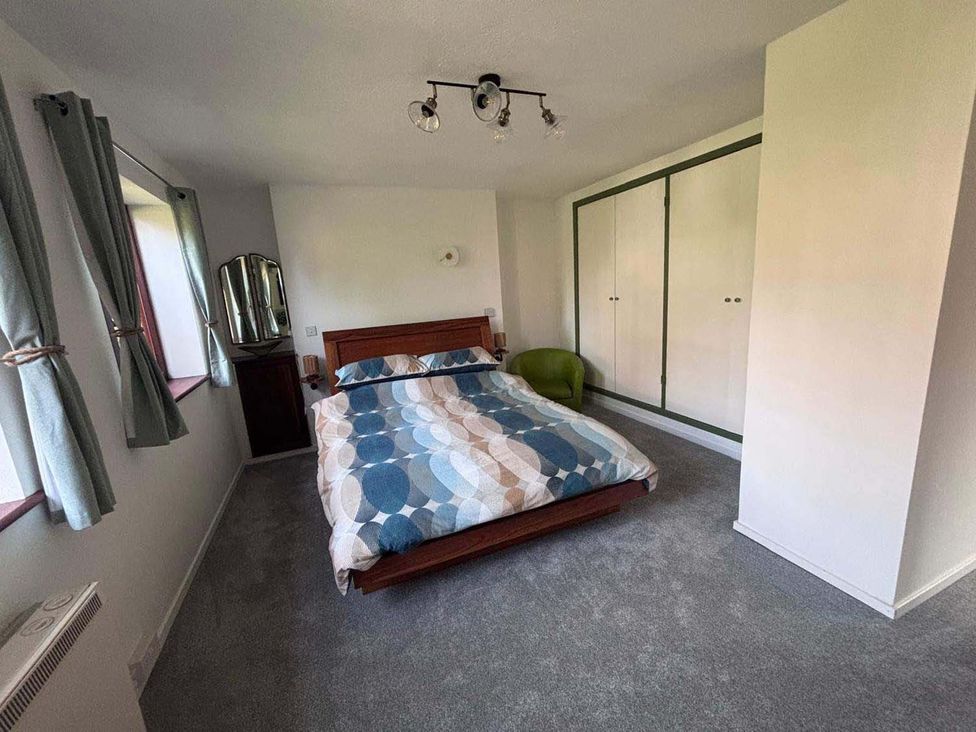 A bedroom with a bed and wardrobe in an unnamed location