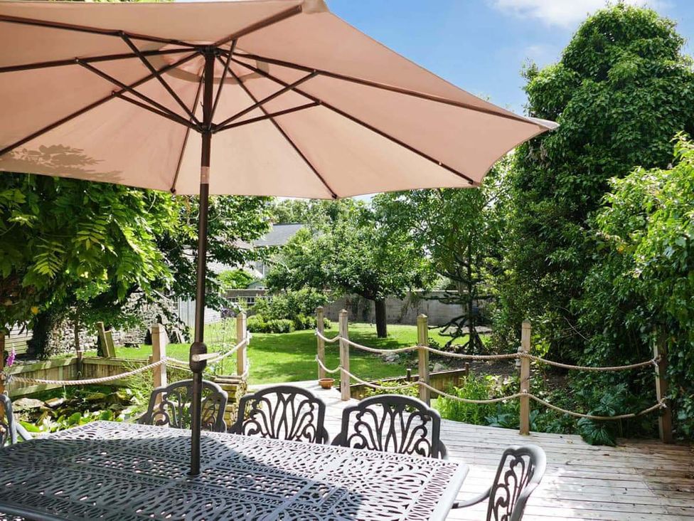 A garden with a table and chairs under an umbrella at a property