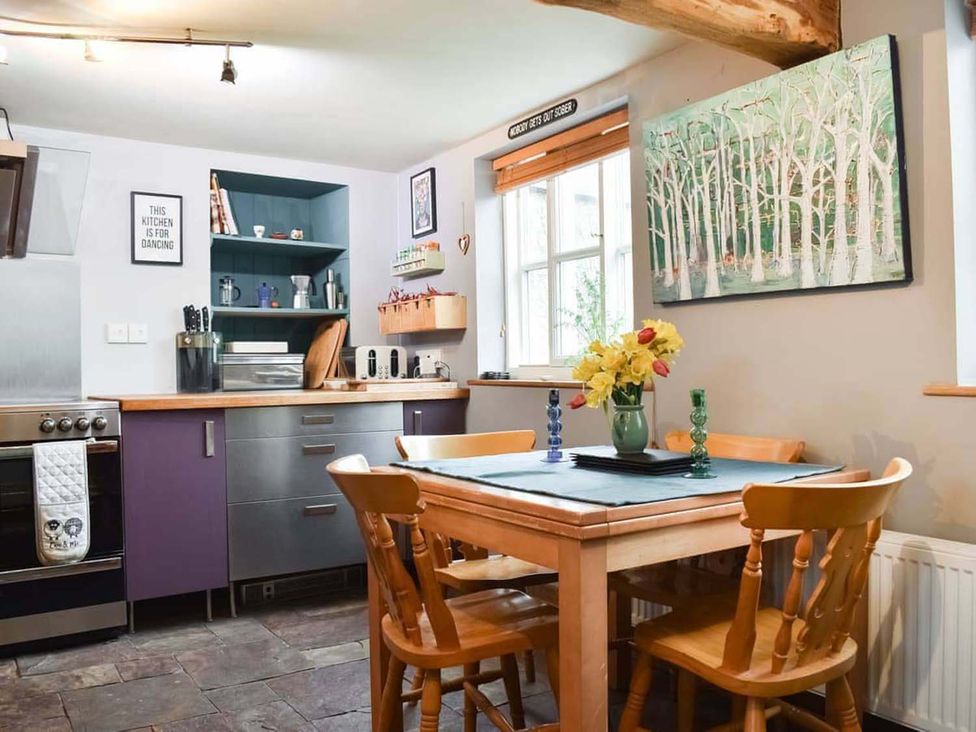 A kitchen with a table and chairs at The Old Barn in Manchester