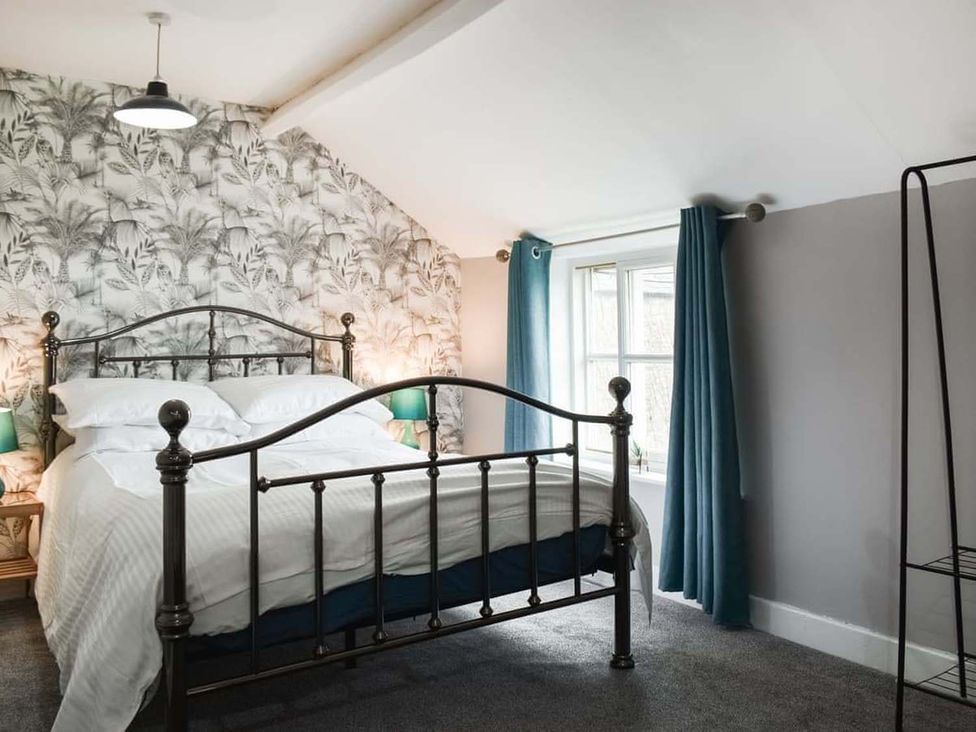 A bedroom with a metal bed and curtains at the property