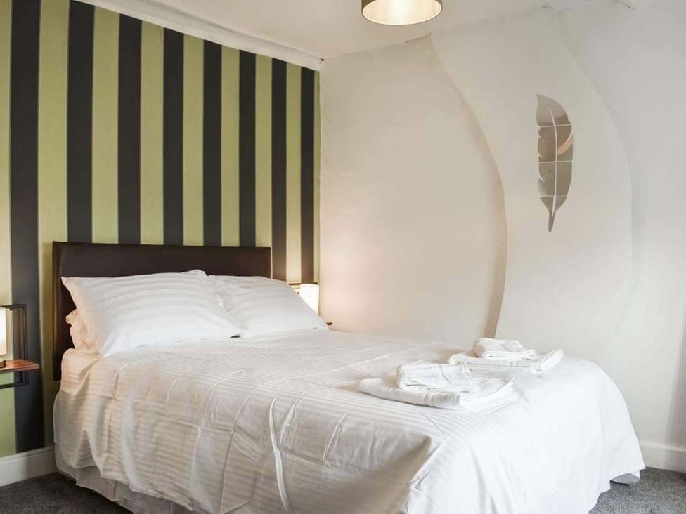 A bedroom with a bed and bedside table at The Old Barn in Manchester