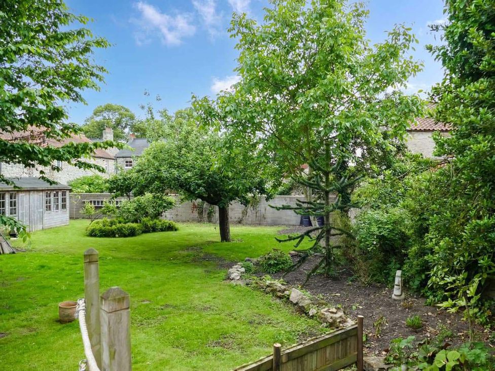 A garden with trees and grass at The Old Barn in Manchester