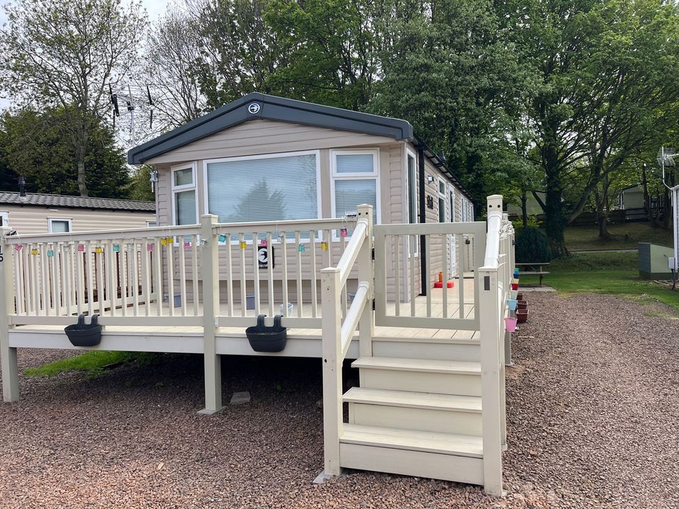 A mobile home with a deck and steps at a holiday park in Builth Wells