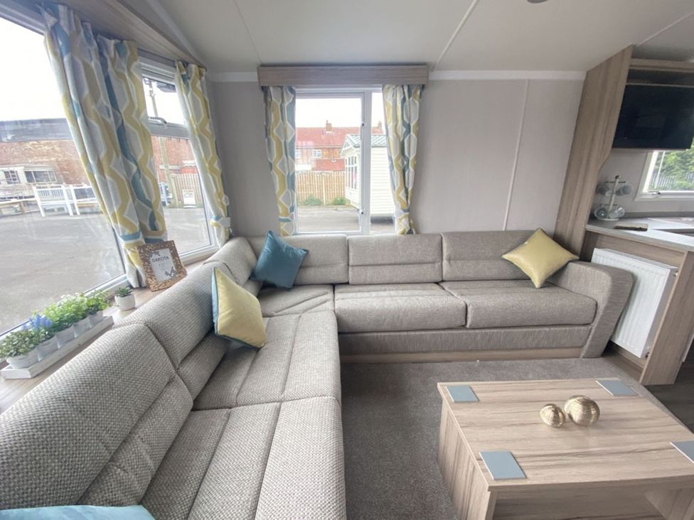 A living room with a sofa and windows at The Old Barn in Builth Wells
