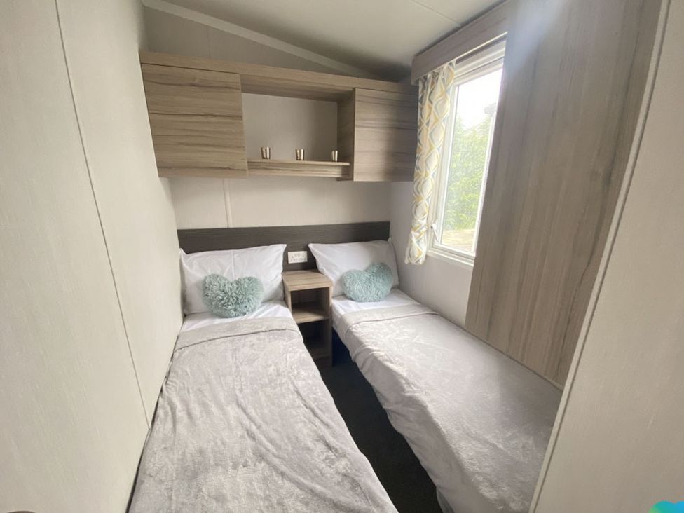 A bedroom with two beds and a window at The Old Barn in Builth Wells