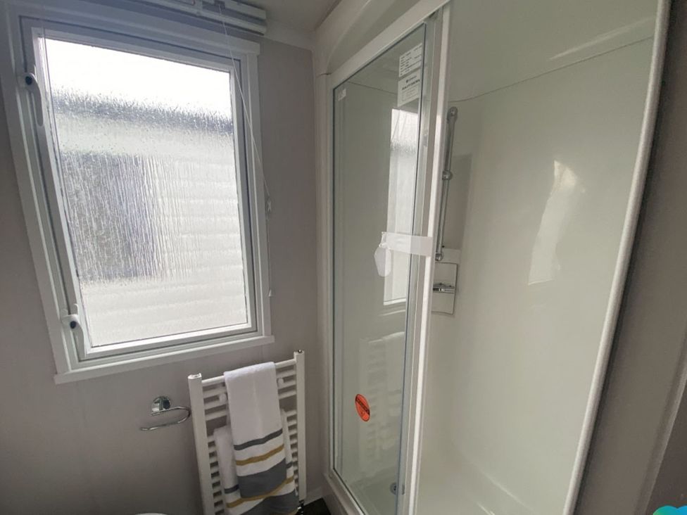 A bathroom with a shower and window at The Old Barn in Builth Wells