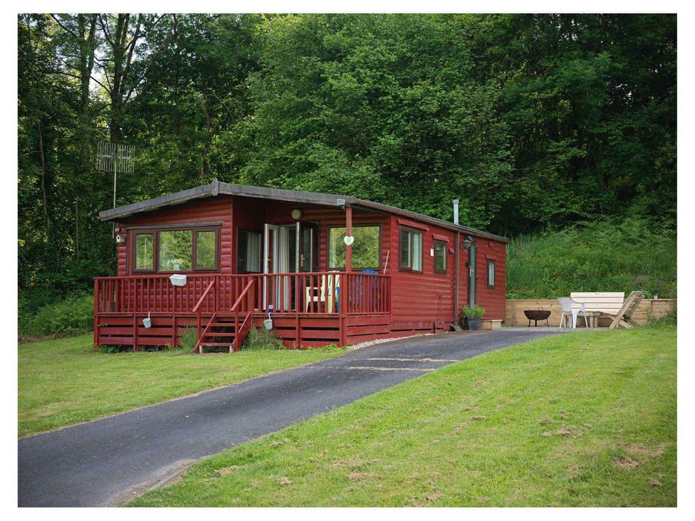 A cabin with a deck and outdoor seating in Builth Wells