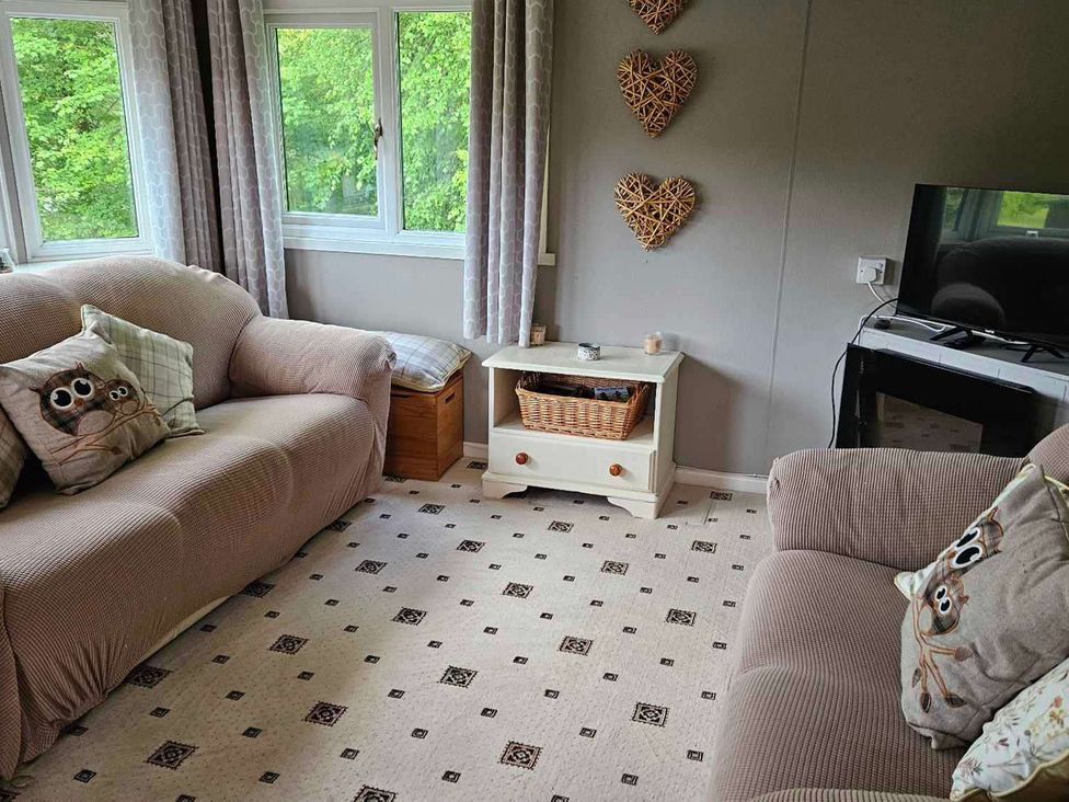 A living room with sofas and a television at the property in Builth Wells
