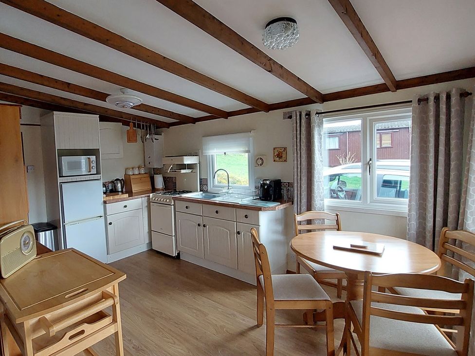 A kitchen with a table and chairs at The Old Barn in Builth Wells
